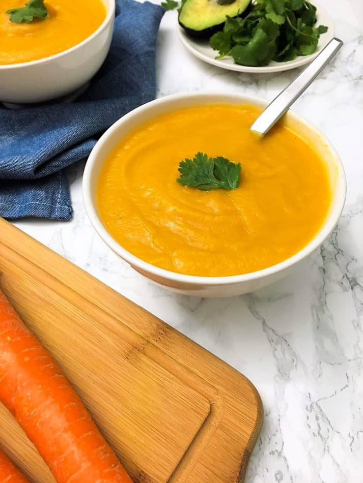 carrot cauliflower soup in bowl garnished with sage