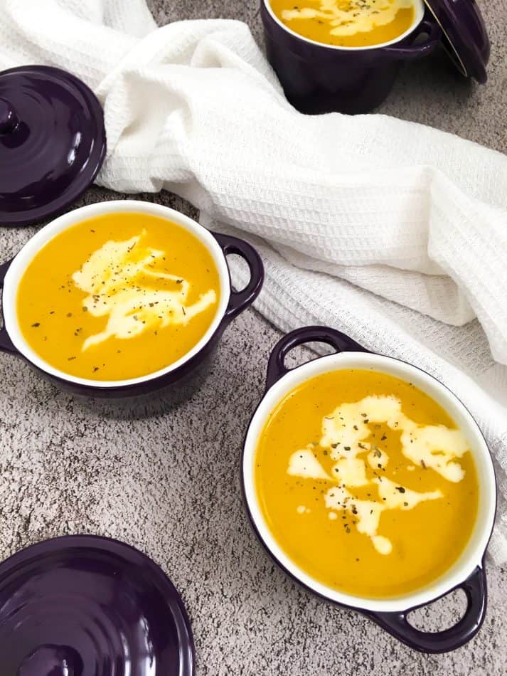soup in purple bowls with vegan sour cream garnish