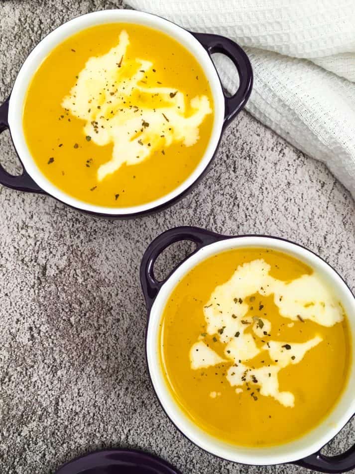 two bowls of soup with cashew cream drizzled on top