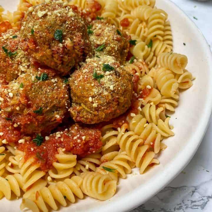 lentil meatballs over bed of rotini pasta with tomato sauce