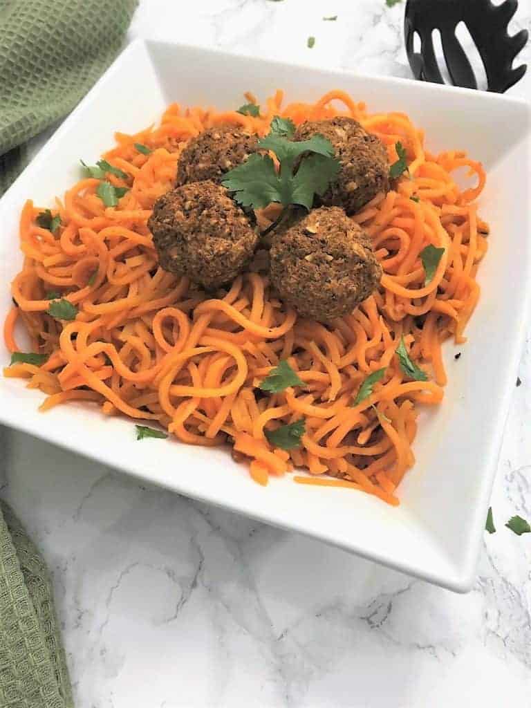 Sweet Potato Noodles topped with lentil vegan meatballs garnished with fresh cilantro