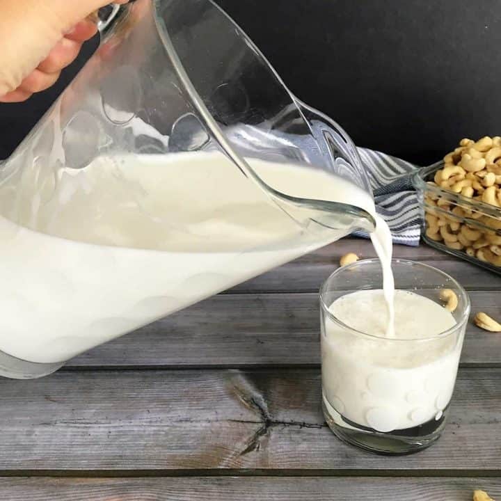 cashew milk pouring from pitcher into glass