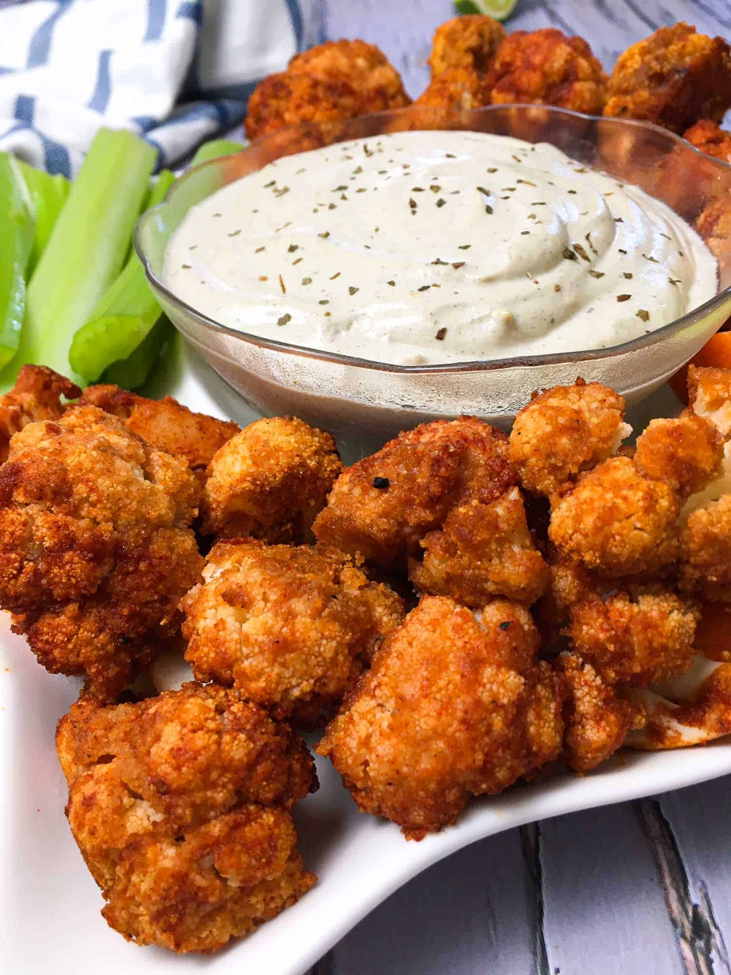 cauliflower wings with buffalo sauce in white serving plate