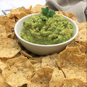 bowl of guacamole surrounded by chips