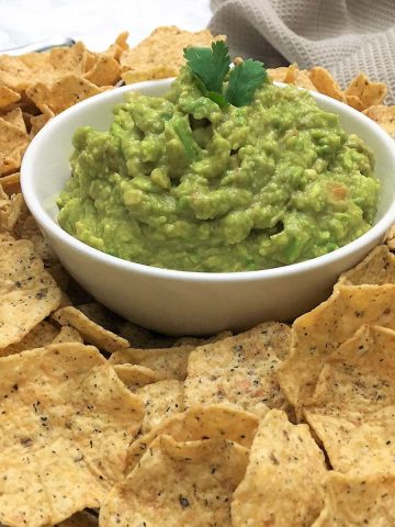 bowl of guacamole surrounded by chips