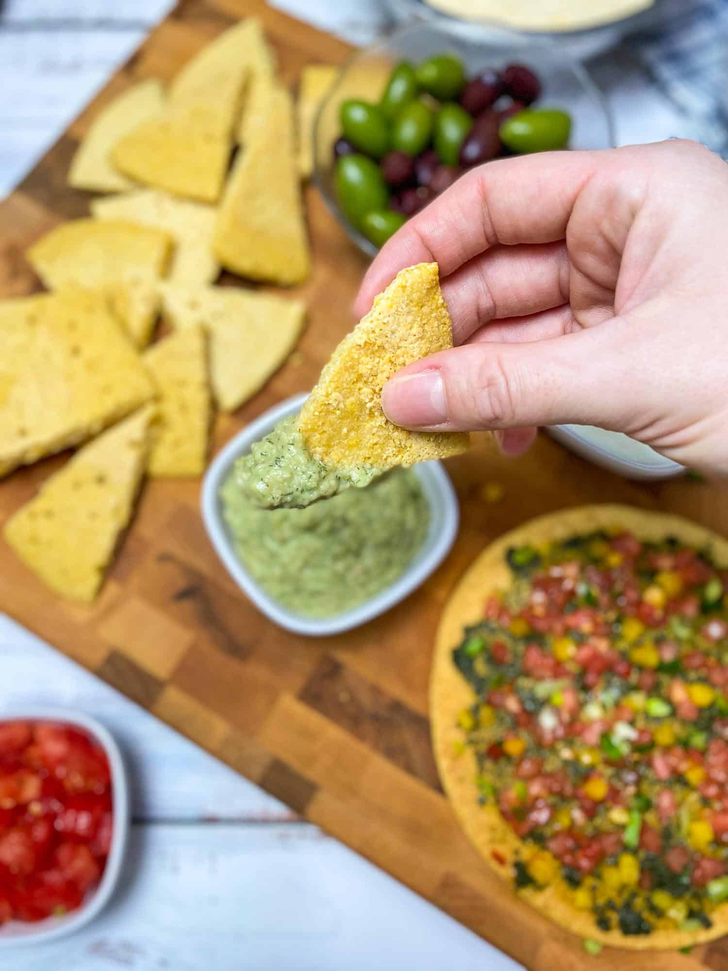 hand holding pita wedge with dip on it