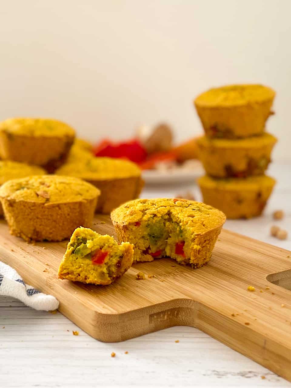 vegan savoury muffin with triangular piece cut out on cutting board.