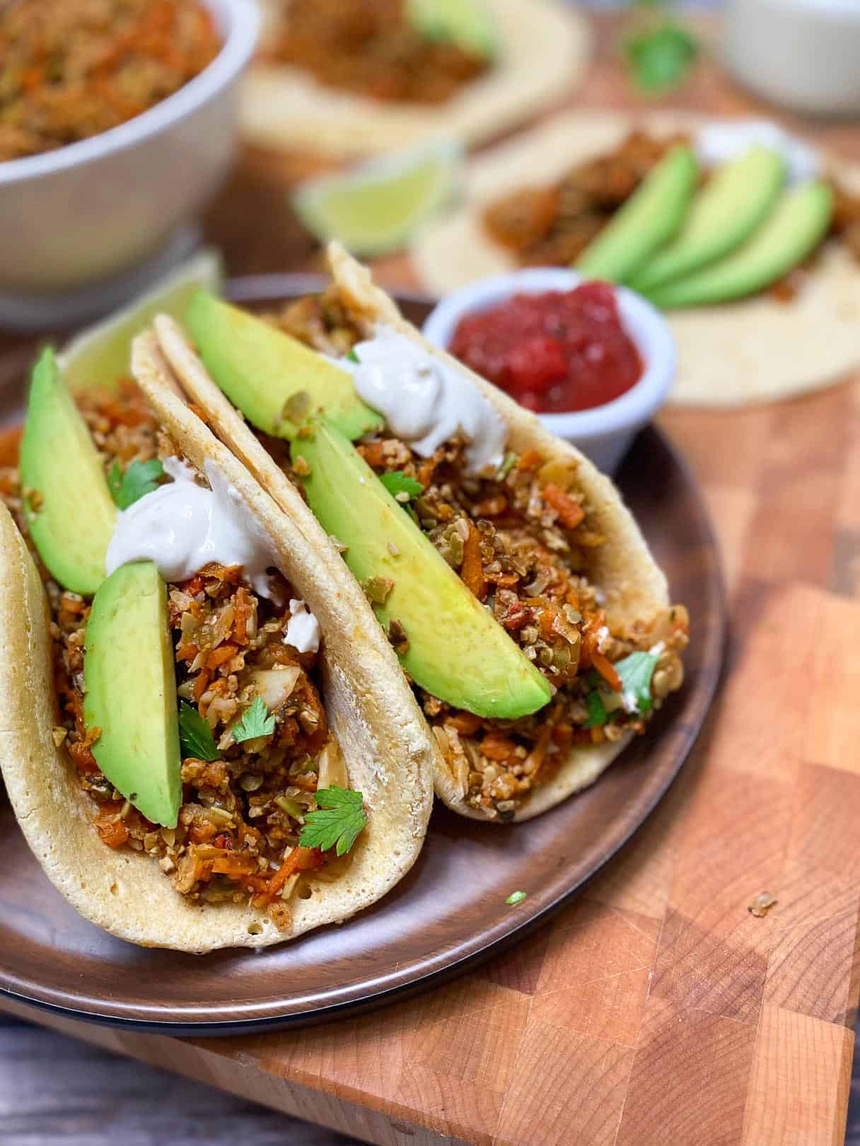 soft tacos on plate with avocado garnish and salsa for dipping