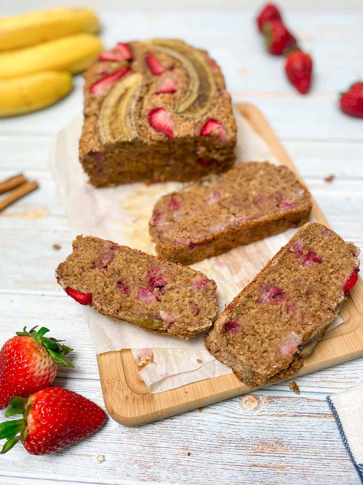 three slices of banana strawberry bread with loaf in the background