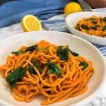 plate of cooked sweet potato noodles and spinach on blue towel