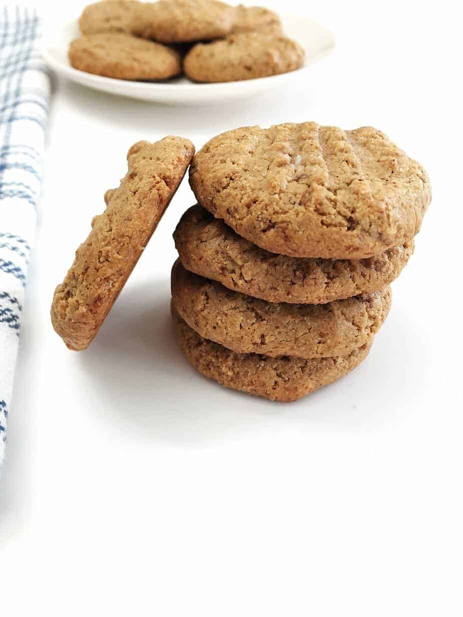stack of almond butter cookies with cookie leaning on side