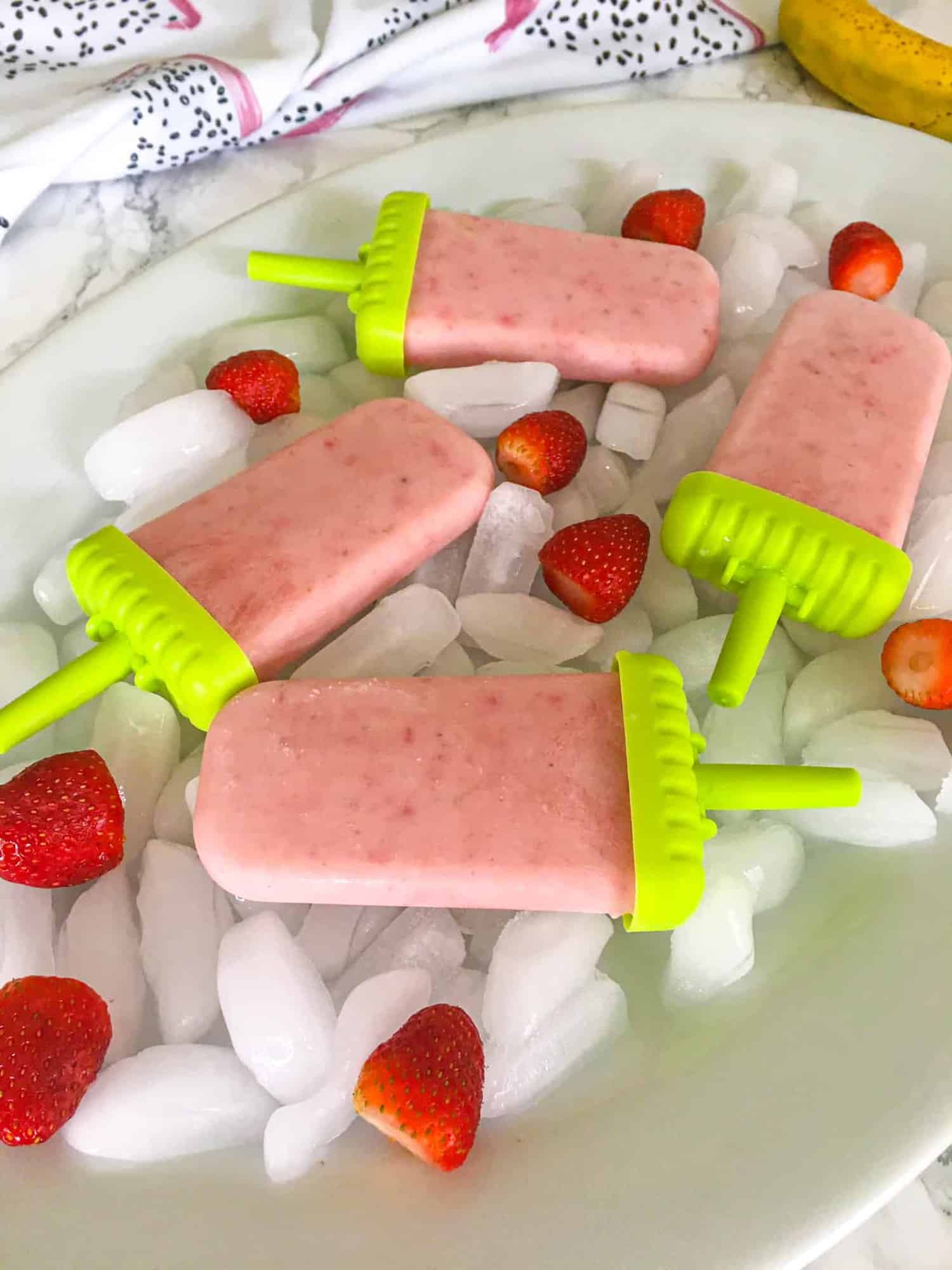 Strawberry Banana Popsicles in large tray of ice cubes