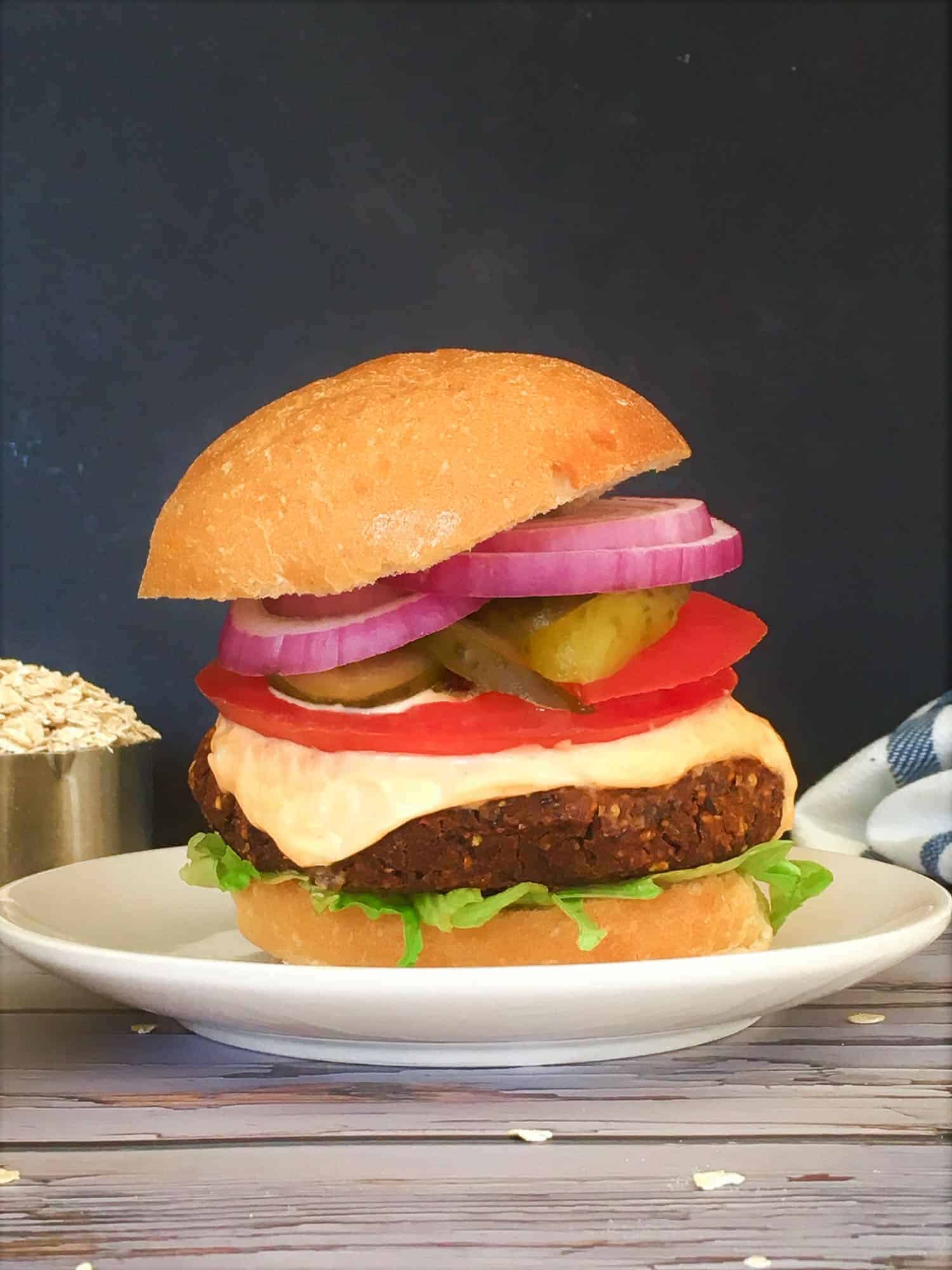 burger in bun with tomato, onion, pickle, spicy mayo