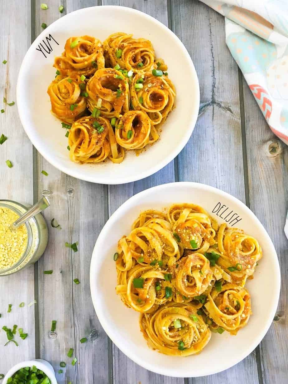 spaghetti spirals in two plates with green onion on top