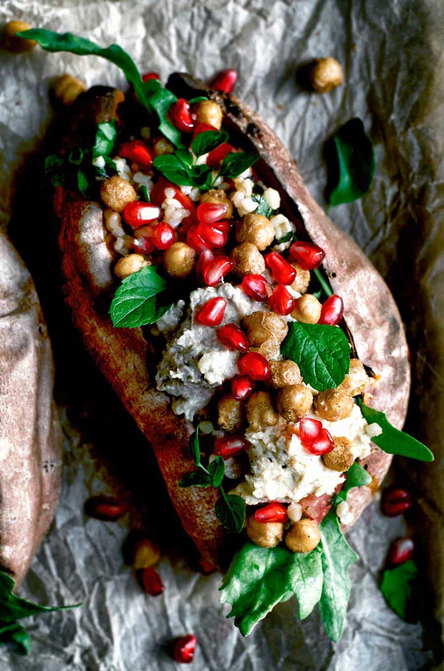 Sweet potato stuffed with chickpeas and rice and topped with pomegranate and mint leaves.