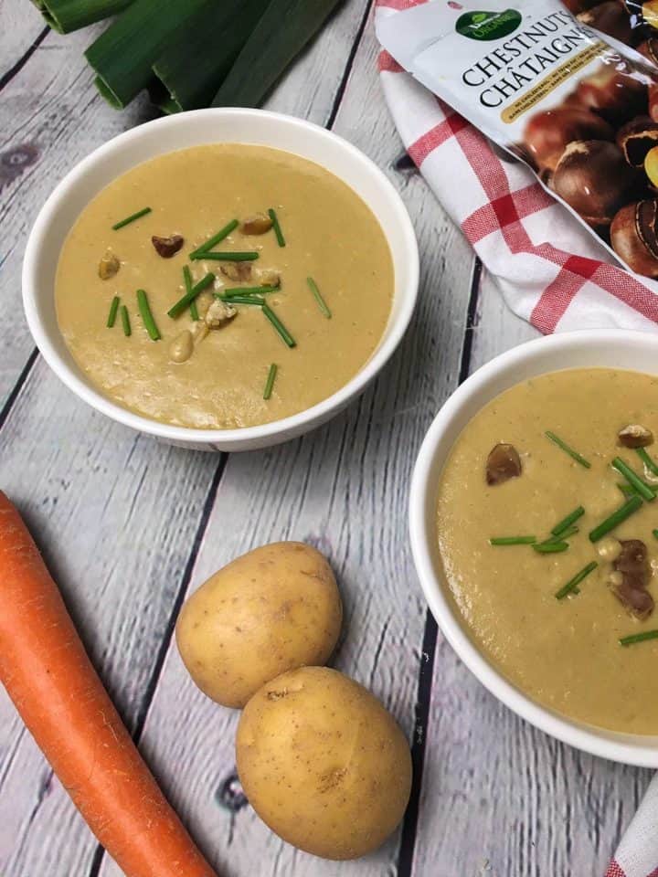 creamy chestnut soup in bowl with chive and chestnut garnish
