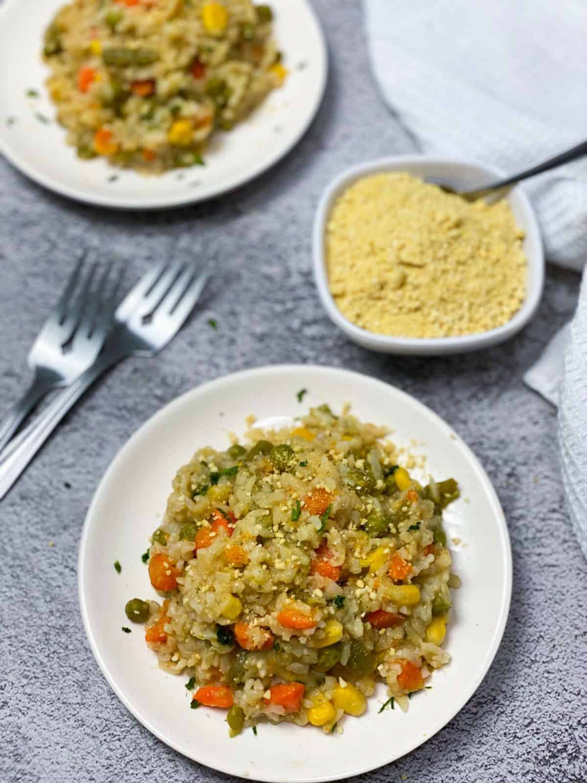 plate of vegetable brown rice risotto with parsley and parmesan garnish