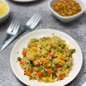 vegan risotto in white plate with mixed vegetables