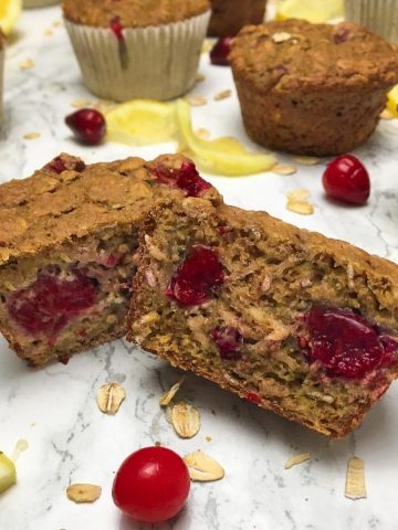 Cranberry muffin sliced in half to expose cranberries inside.