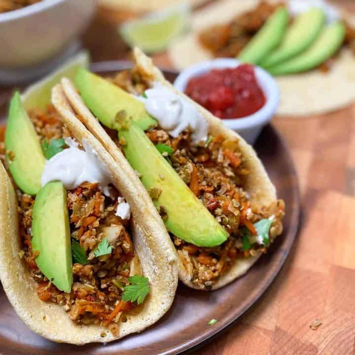 soft tacos on plate with avocado garnish and salsa for dipping
