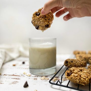 cookie being dipped into glass of milk