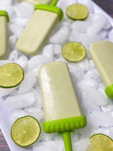 white tray of ice with coconut lime popsicles on top