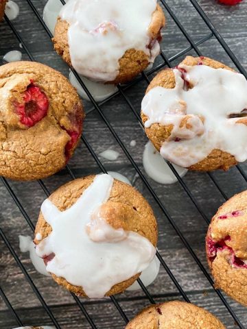 vegan raspberry muffins with white glaze on cooling rack