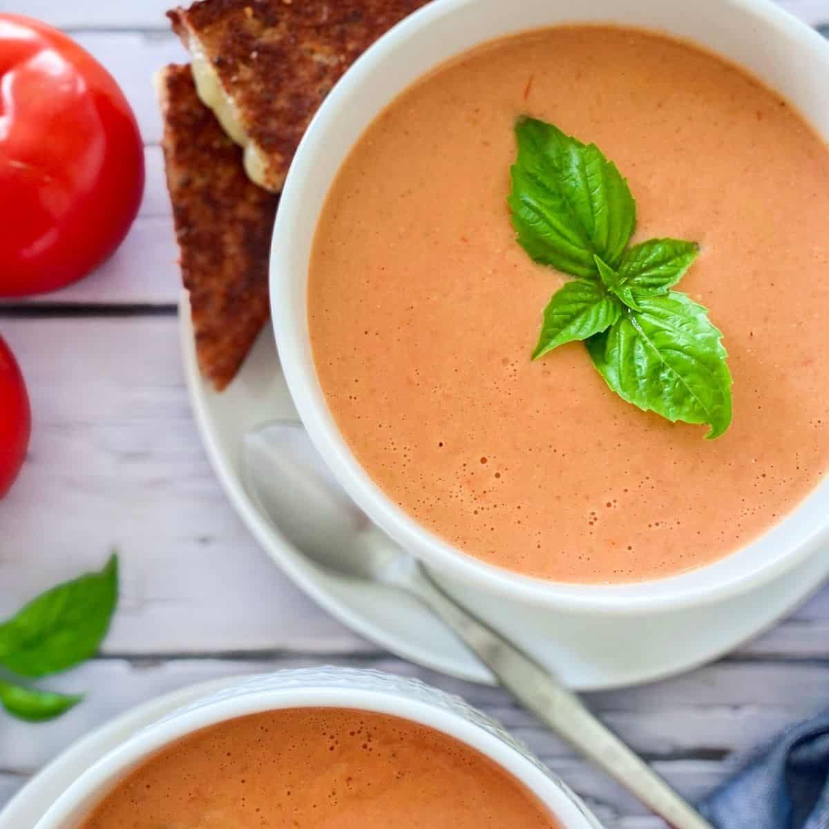 bowl of tomato soup with basil garnish on top