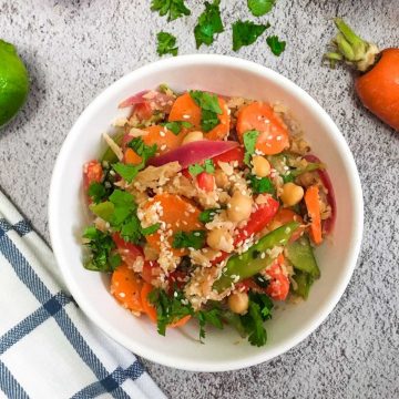 White bowl of cauliflower rice and vegetables in peanut sauce.