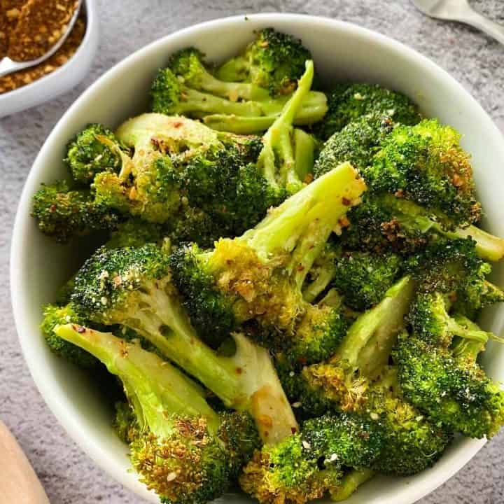 close up of bowl full of air fried broccoli