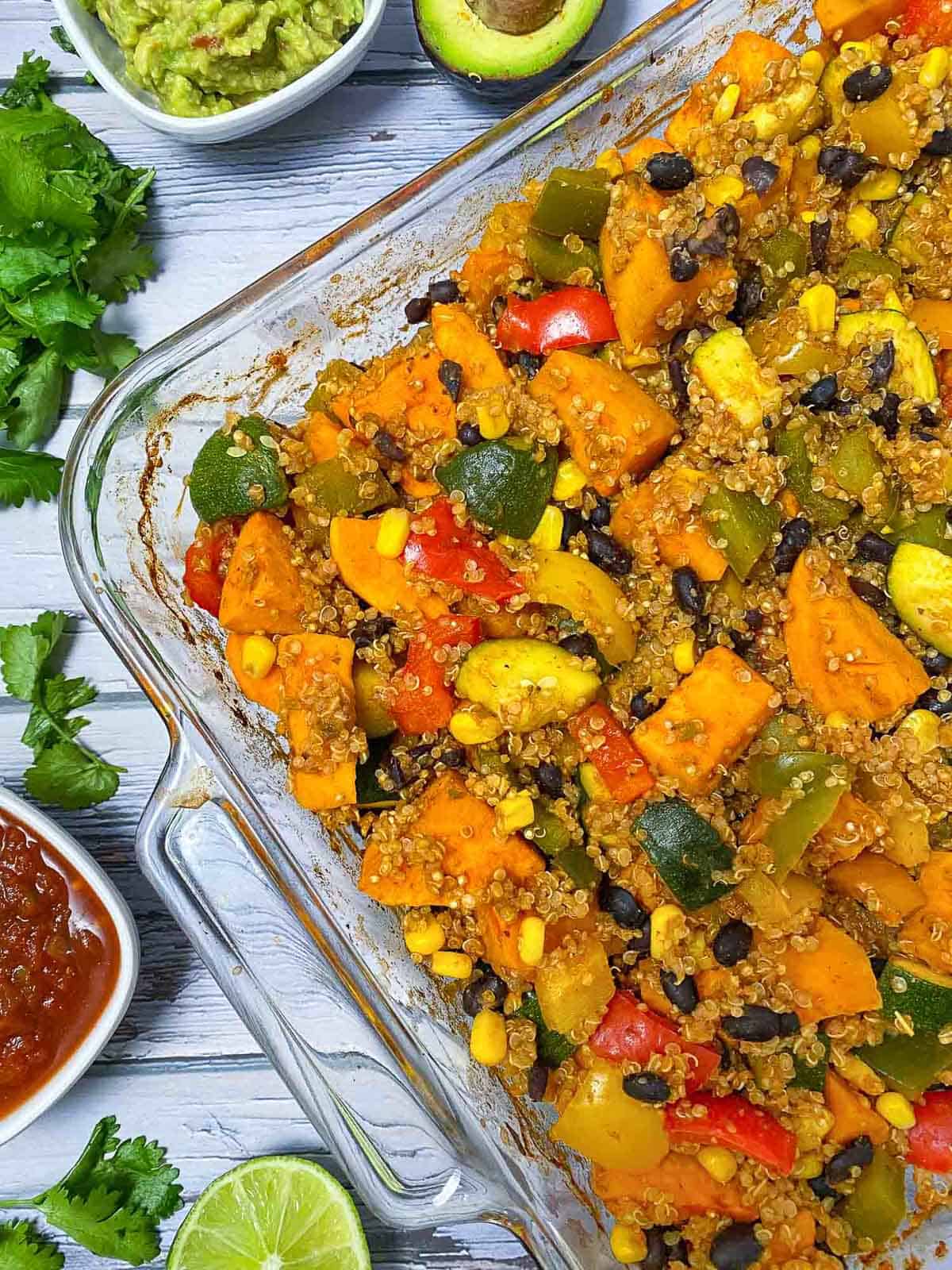 Casserole dish with sweet potato, zucchini, peppers, black beans and quinoa inside,