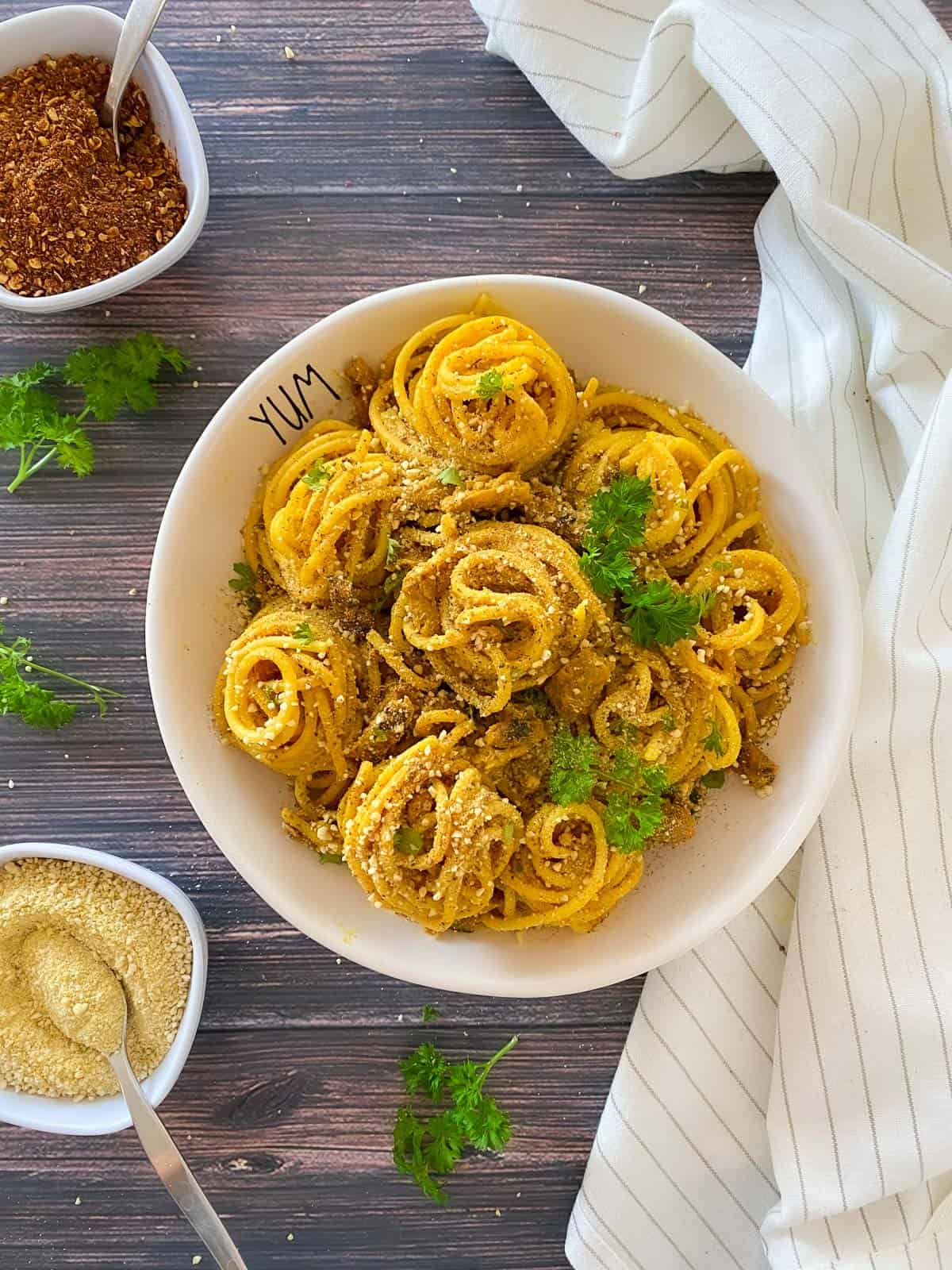 Vegan carbonara spaghetti in white bowl with parsley garnish.