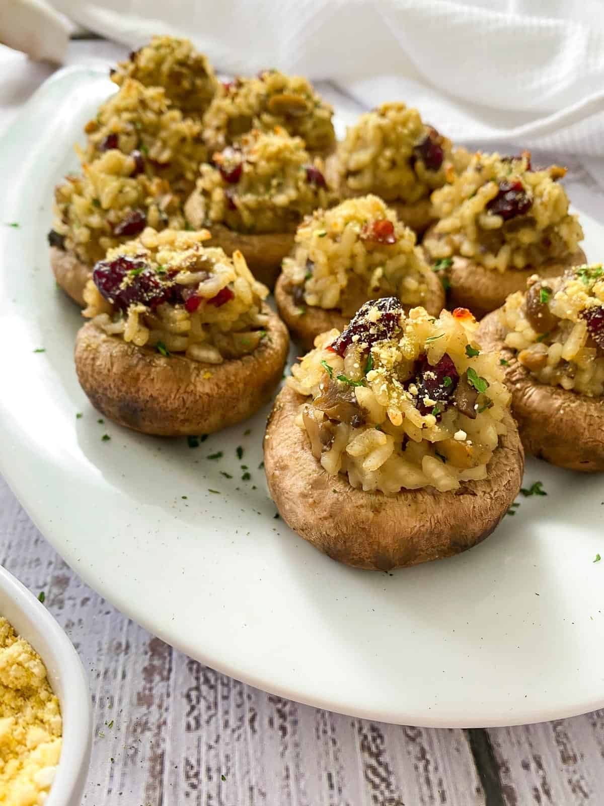 Stuffed mushrooms with rice and cranberries on white plater.