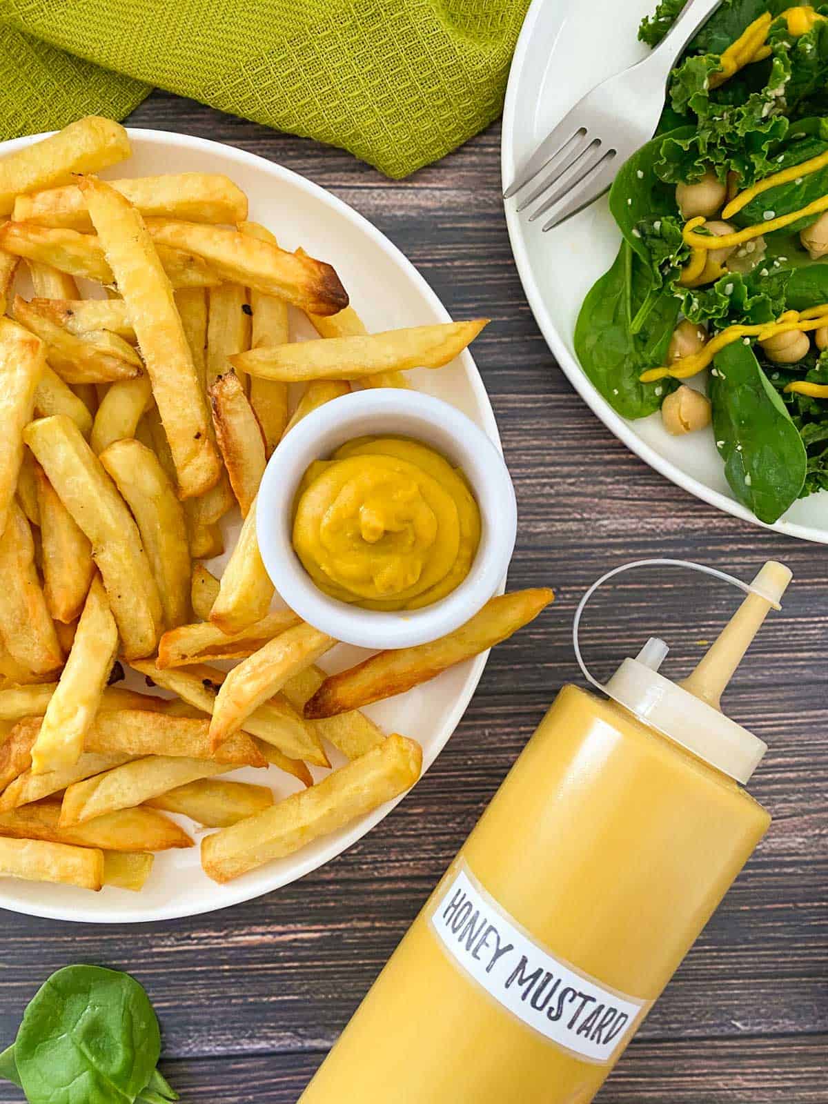 Plate of french fries with small dipping bowl filled with honey mustard.