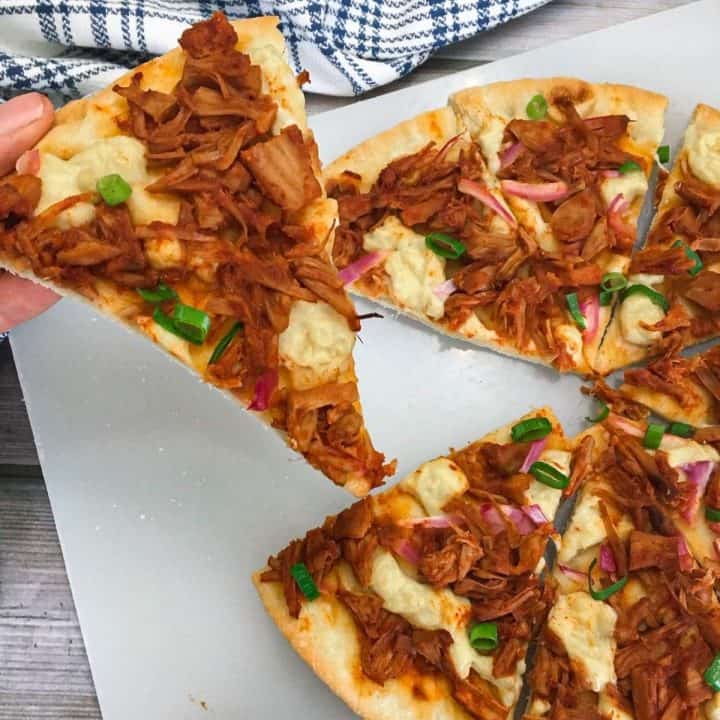 hand lifting slice of pizza