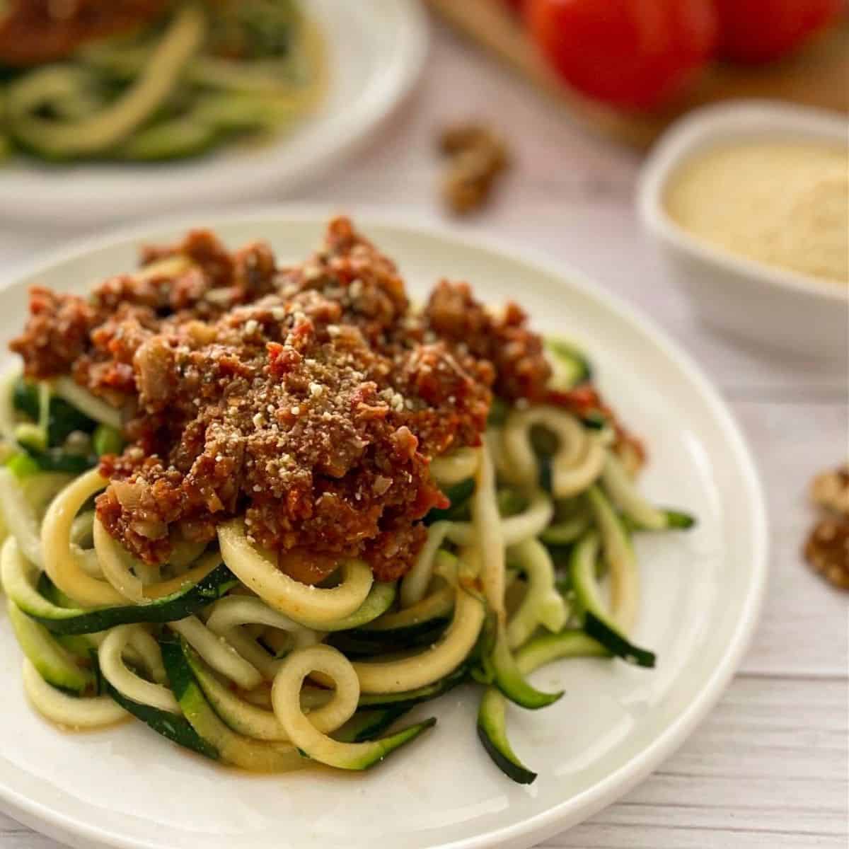 plate of zucchini noodles with bolognese sauce on top.