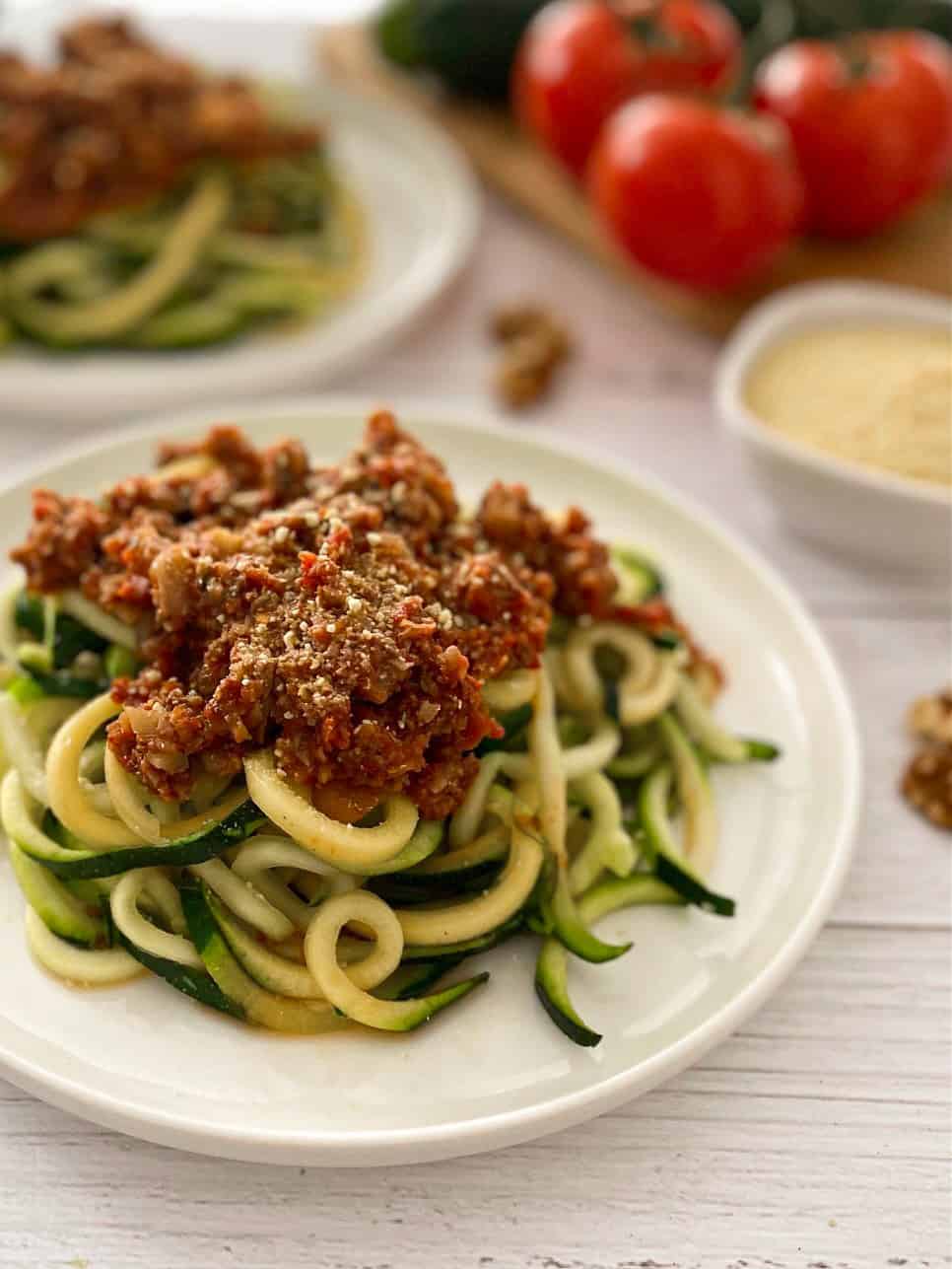 plate of zucchini noodles with bolognese sauce on top.
