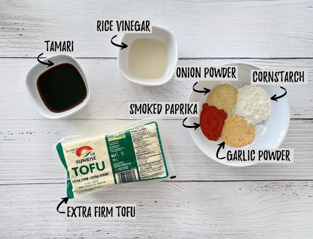 Block of tofu, bowl of seasoning and bowl of soy sauce and vinegar on white deck.
