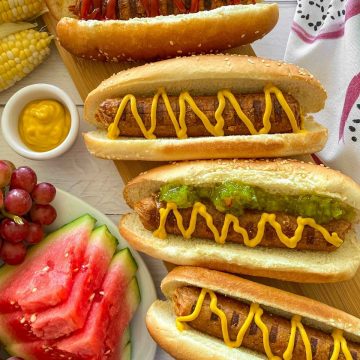 Vegan hot dogs in buns with mustard and relish on top.
