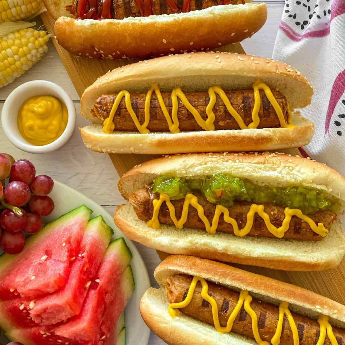 Vegan hot dogs in buns with mustard and relish on top.