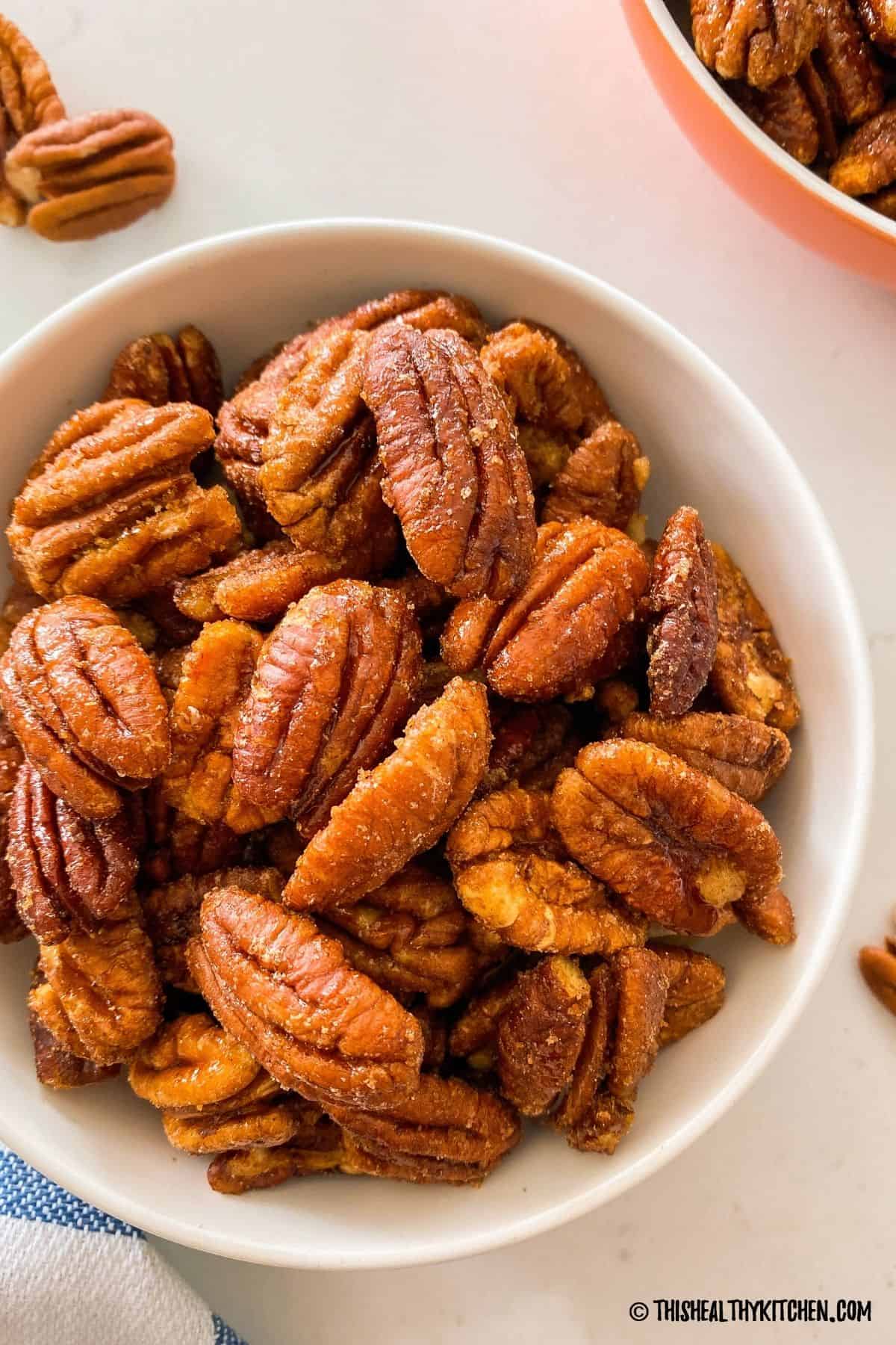 Air fried candied pecans in white bowl.