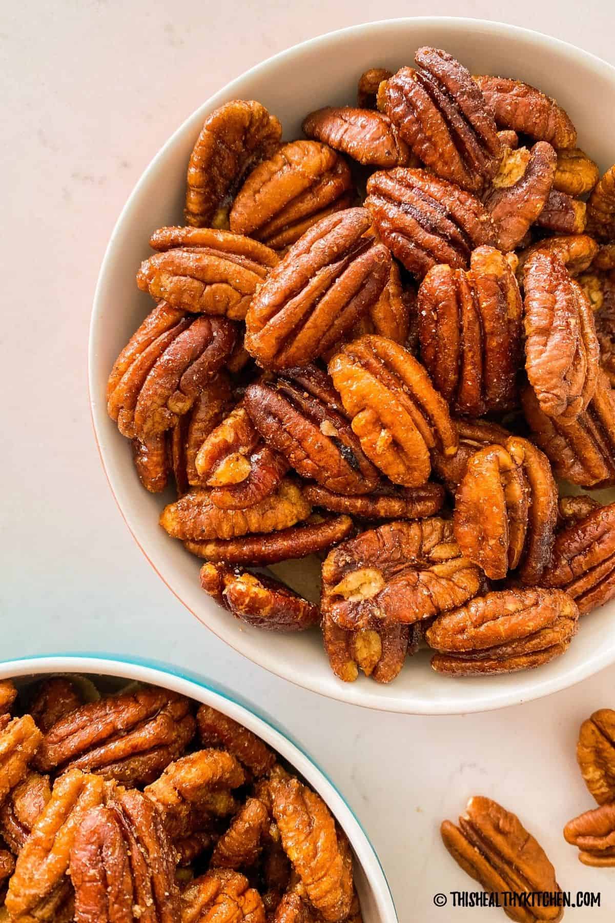 Candied pecans with savoury spices in white bowl.
