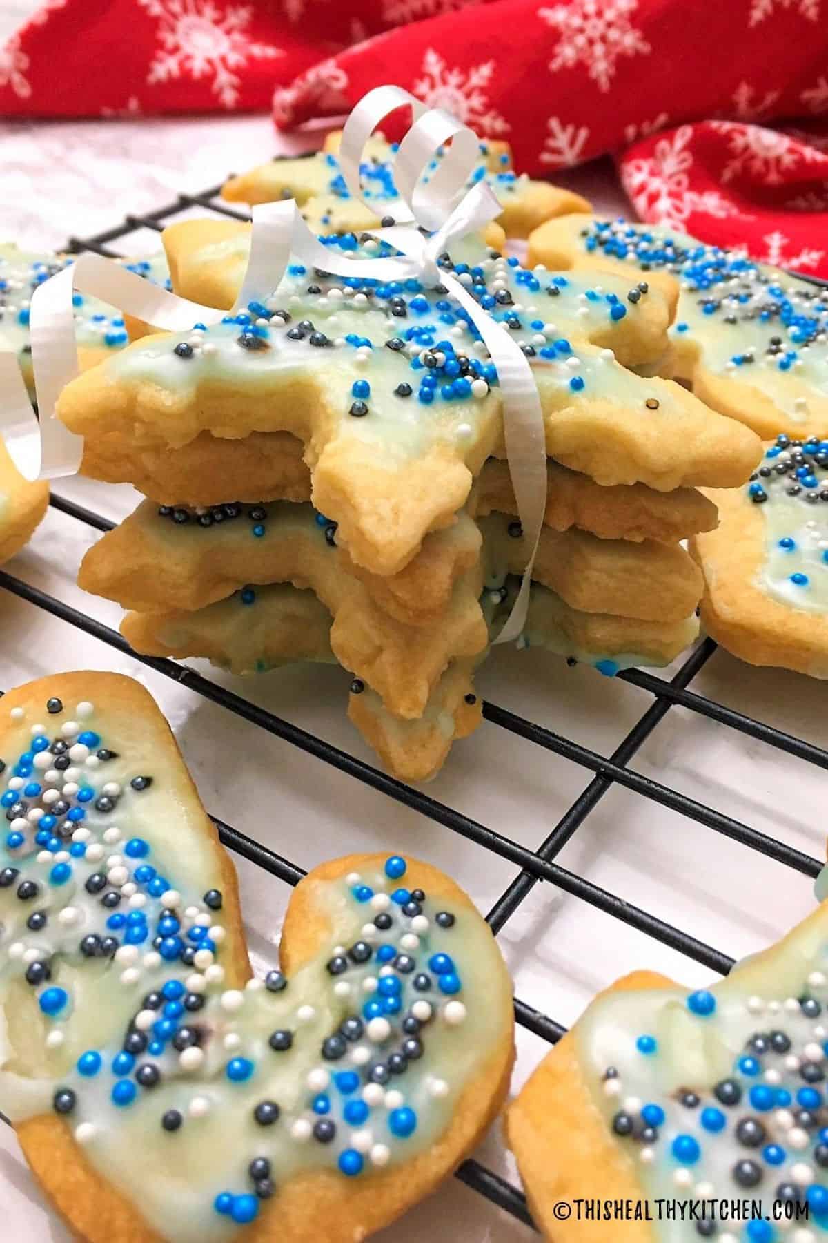 Stack of 4 star shaped cookies with white ribbon wrapped around them and tied in a bow.