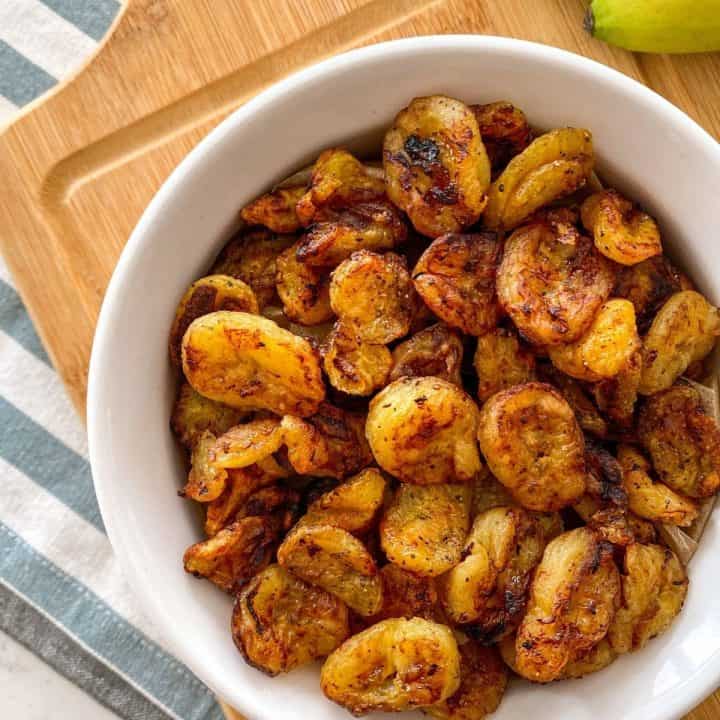 Air fried banana chips in white bowl.