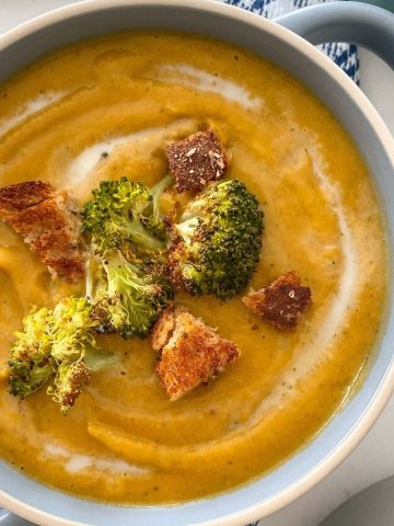 Blue bowl filled with broccoli and sweet potato soup.