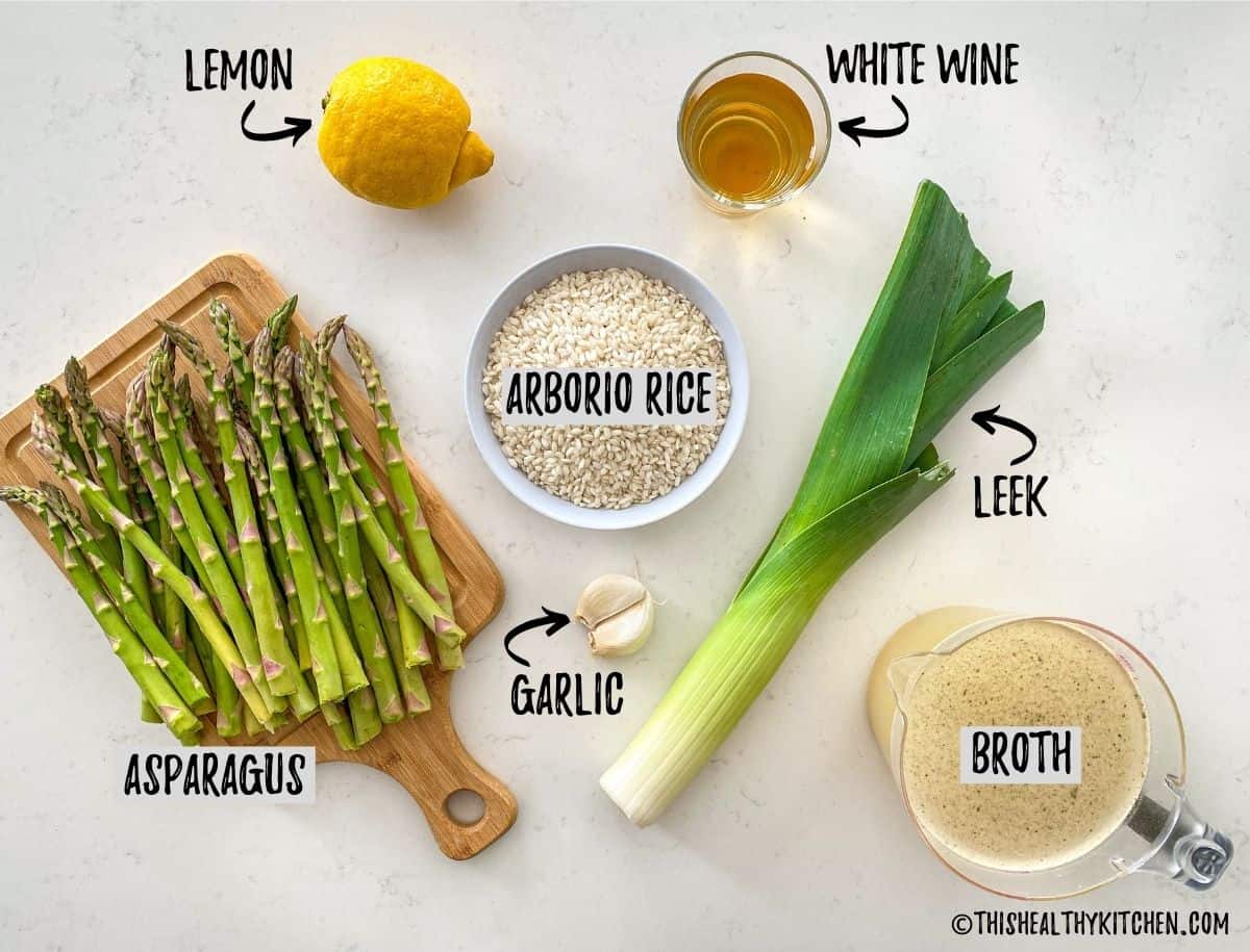 Ingredients needed to make asparagus lemon risotto scattered on kitchen counter.