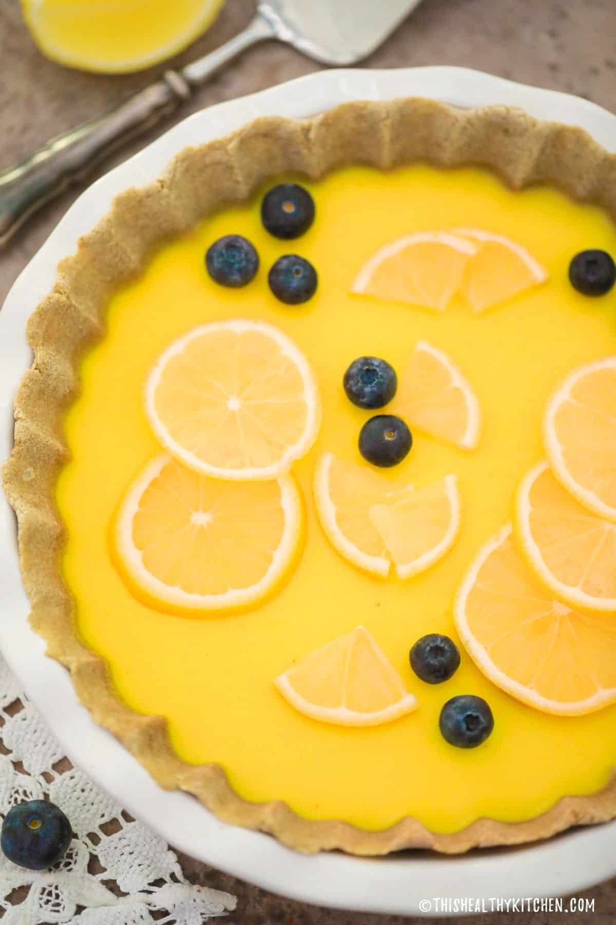 Lemon pie with lemon slices and blueberries on top.
