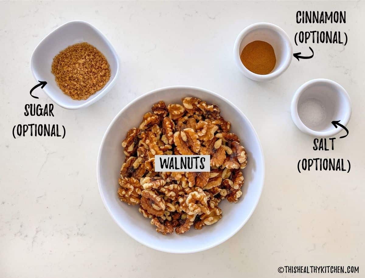 Bowl of walnuts, bowl of sugar and small bowls of cinnamon and salt on kitchen countertop.