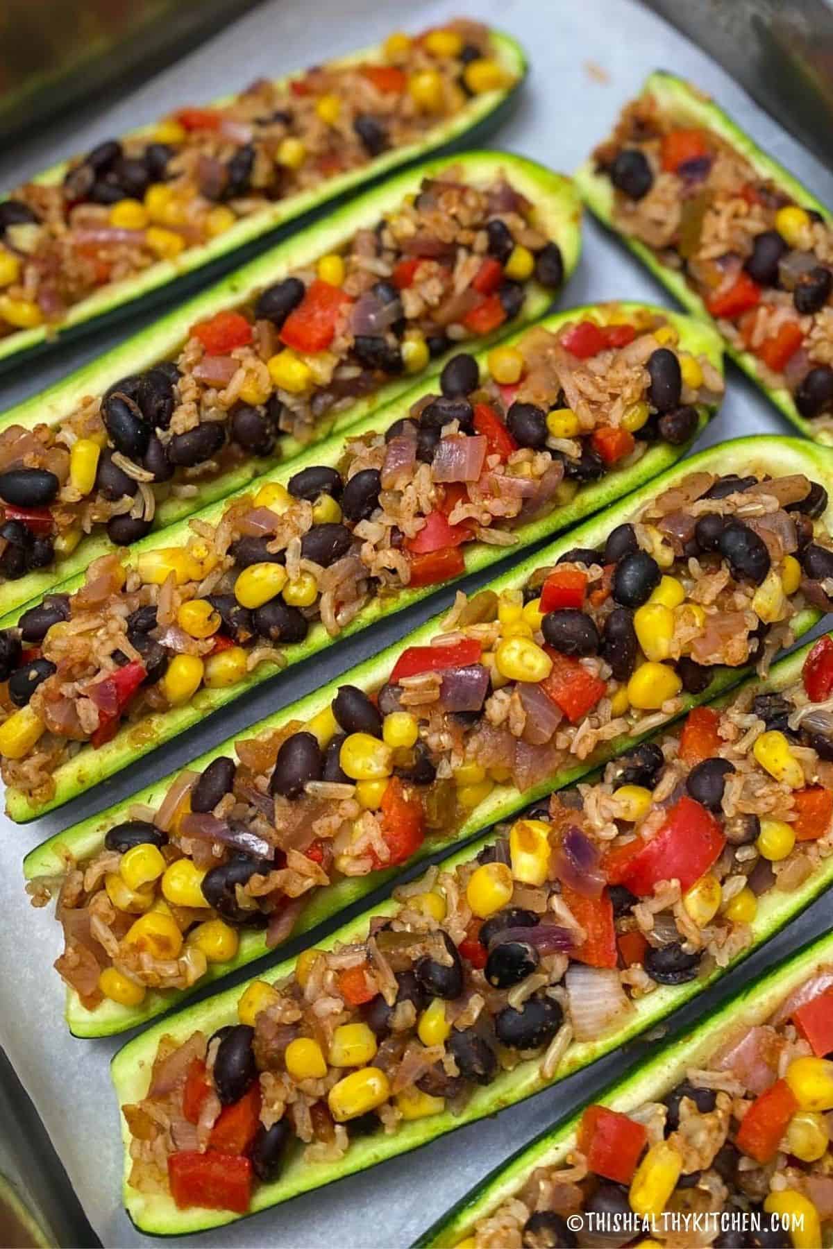 Close up of vegan zucchini boats with burrito toppings inside.