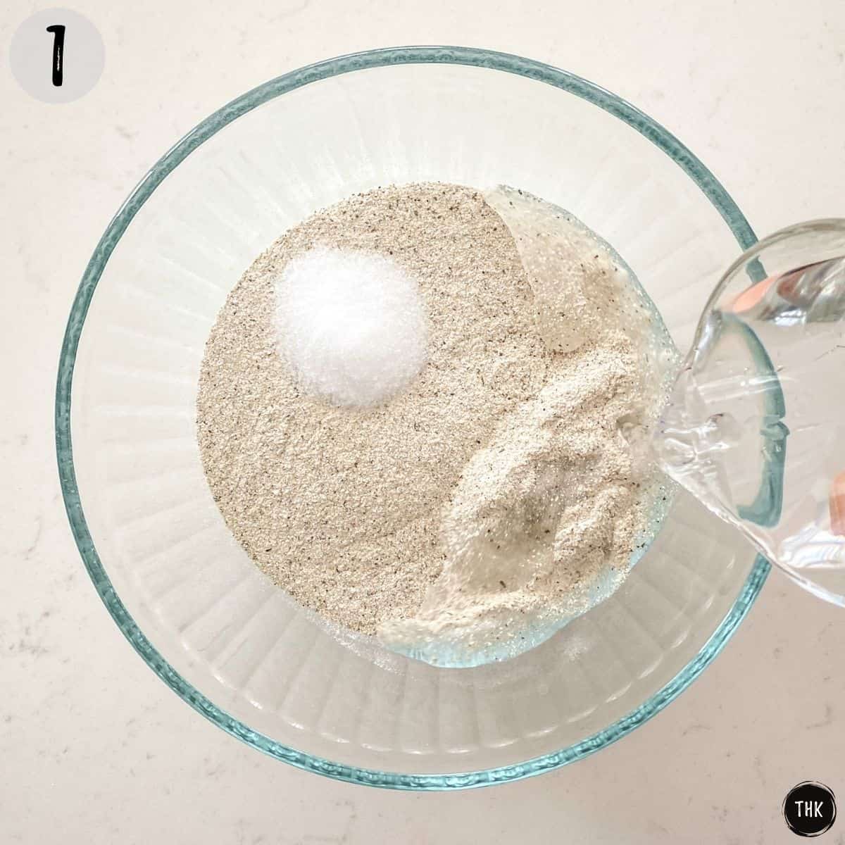 Pouring water into bowl with flour and salt.